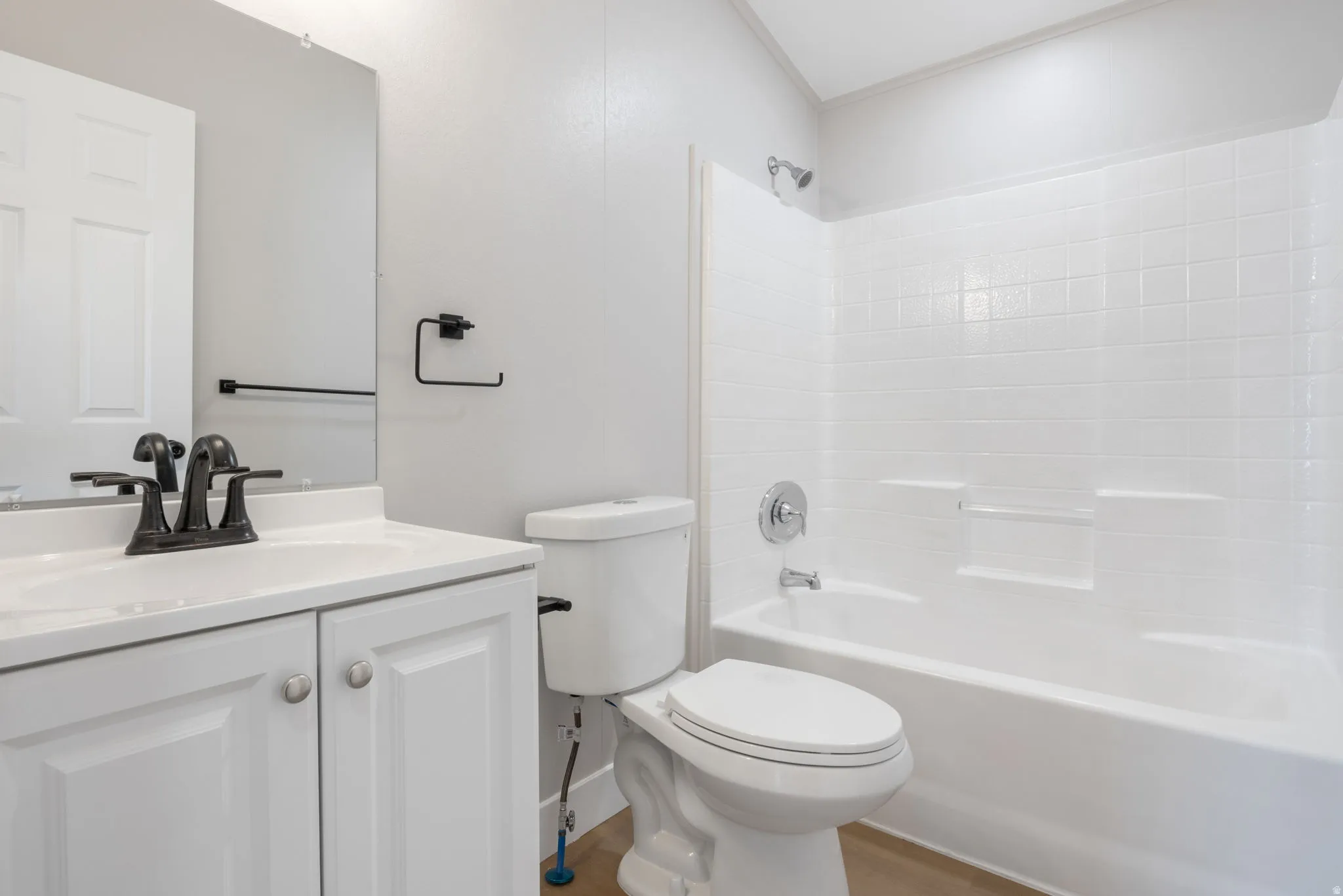 Bathroom featuring bathing tub / shower combination, vanity, and wood finished floors
