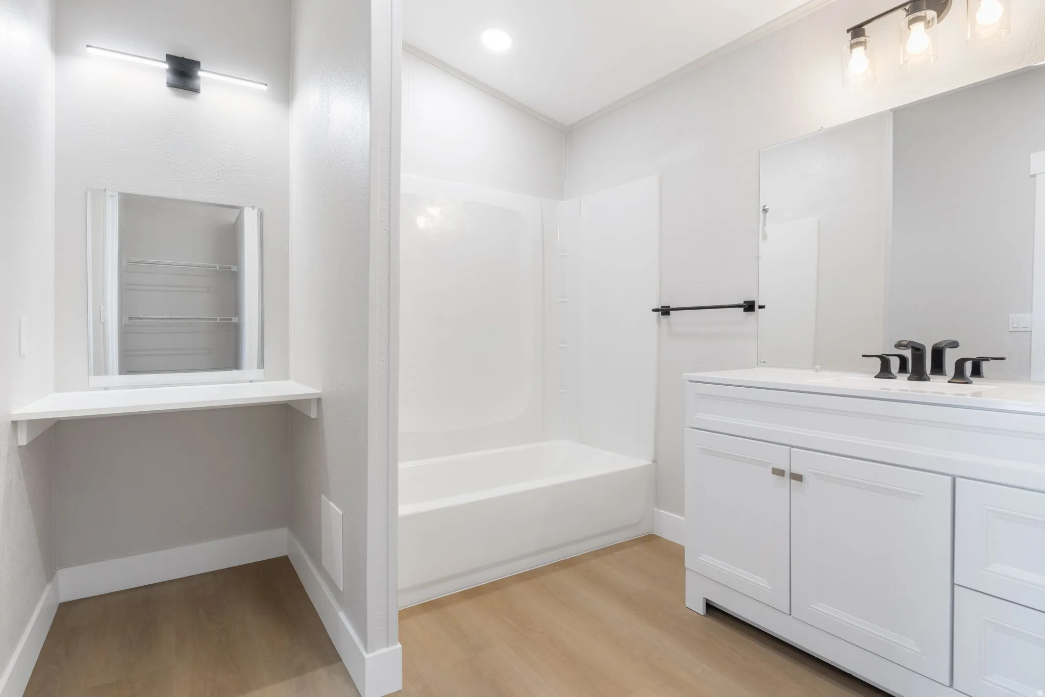 Bathroom featuring vanity, light wood-style floors, and tub / shower combination