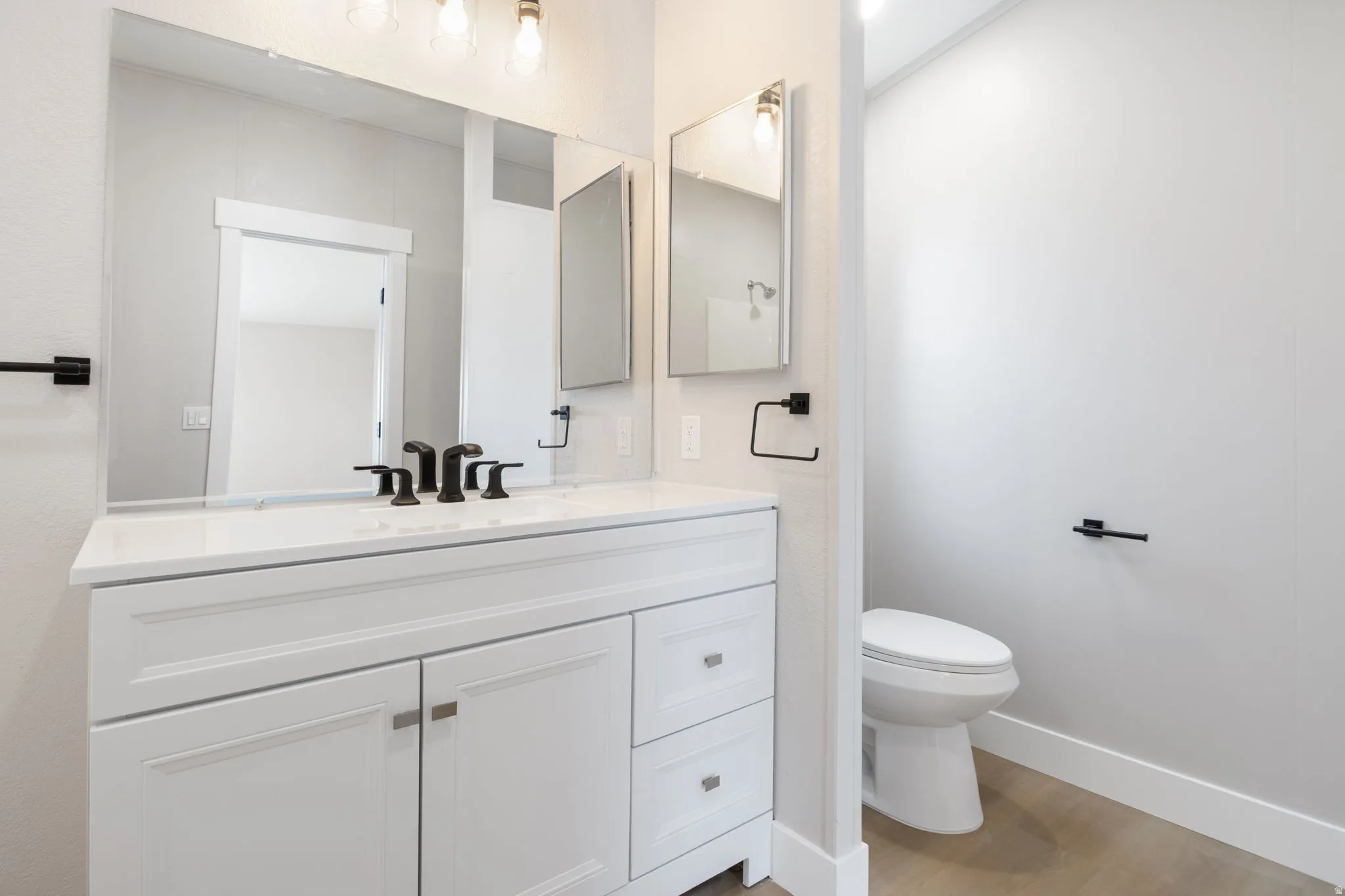 Half bathroom featuring vanity and light wood finished floors
