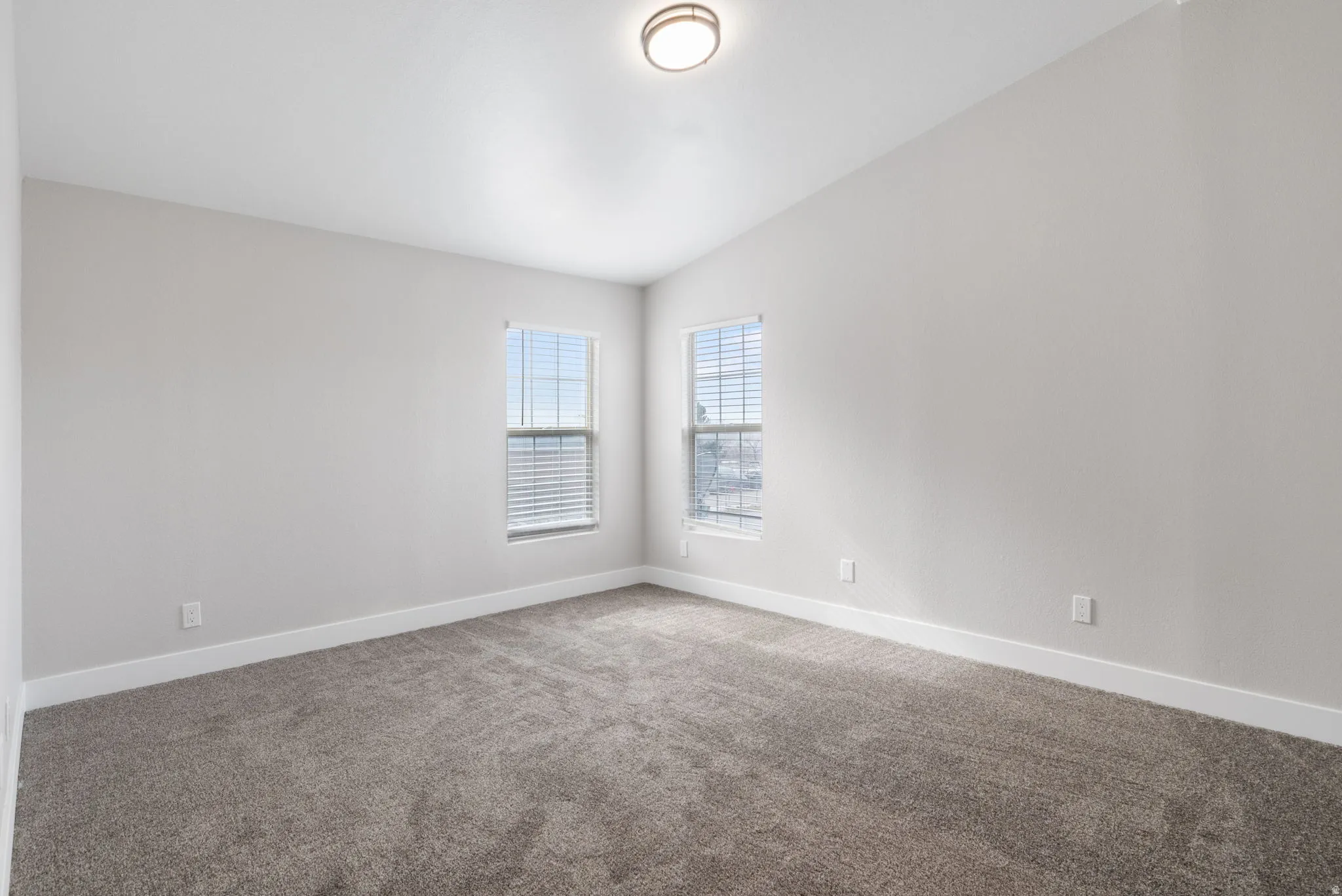 Unfurnished room with lofted ceiling and carpet flooring