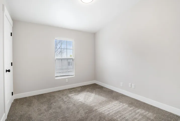 Unfurnished room featuring carpet and baseboards