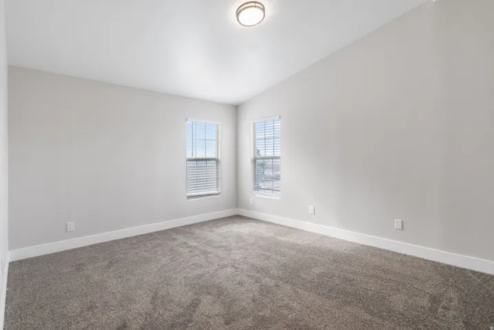 Unfurnished room with lofted ceiling and carpet flooring