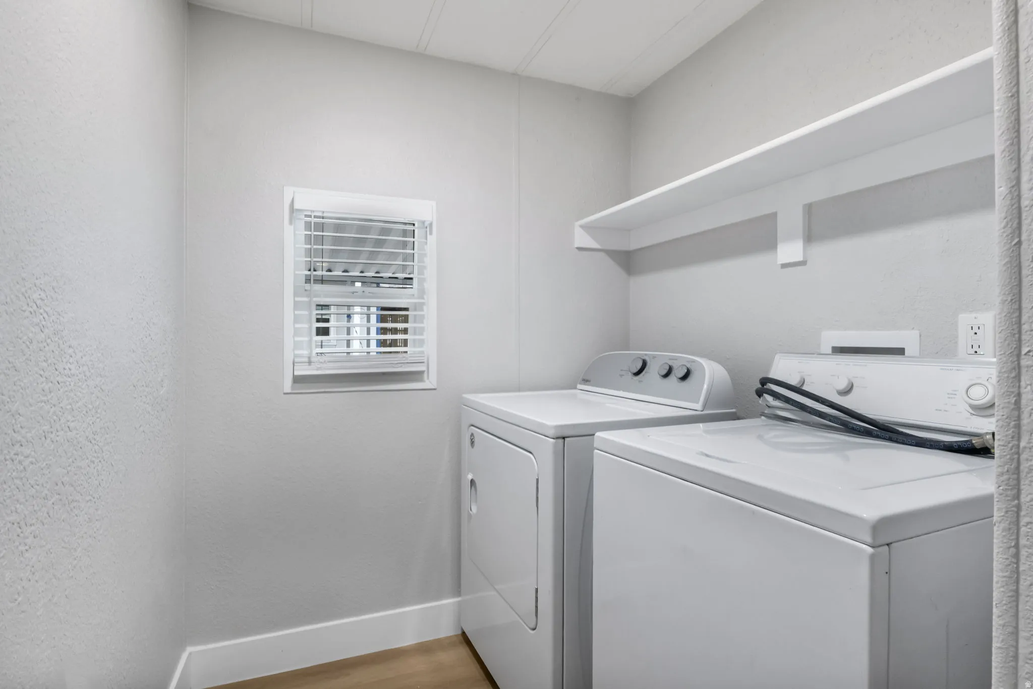 Laundry area featuring light wood-style flooring and washer and dryer