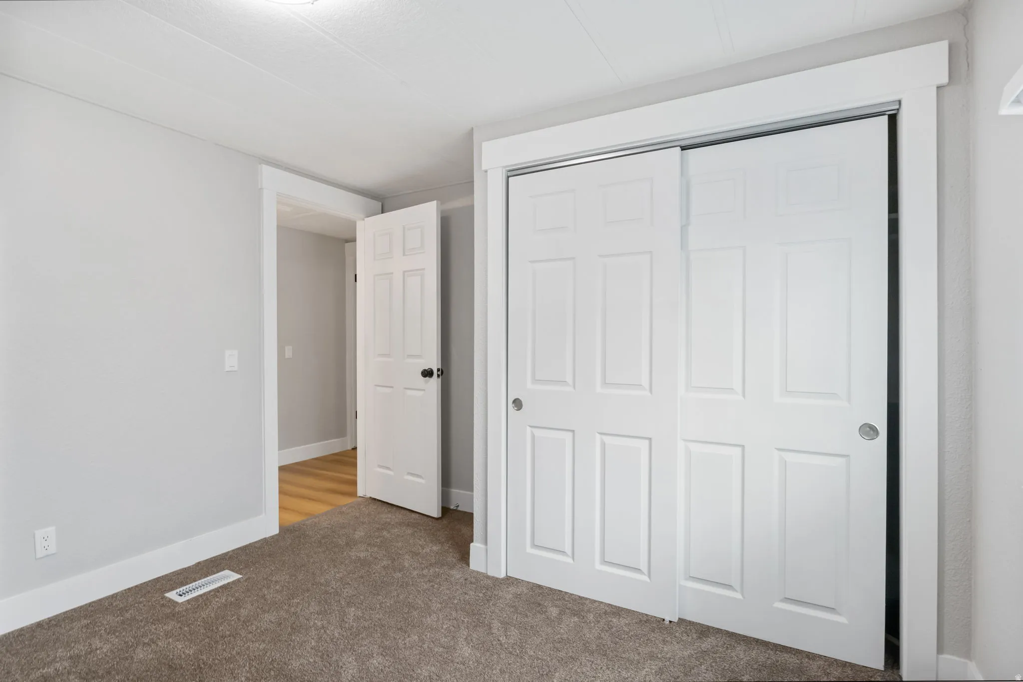 Unfurnished bedroom featuring carpet and a closet