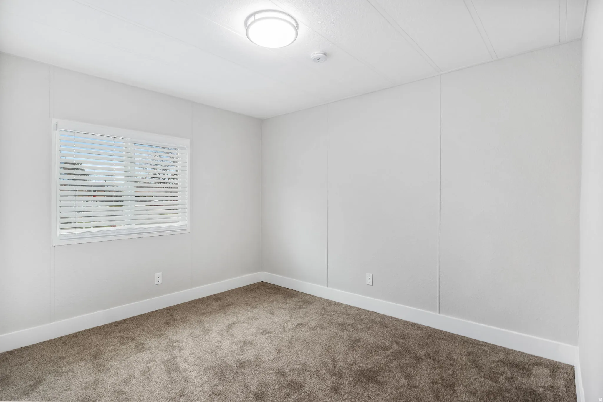 Carpeted empty room featuring baseboards