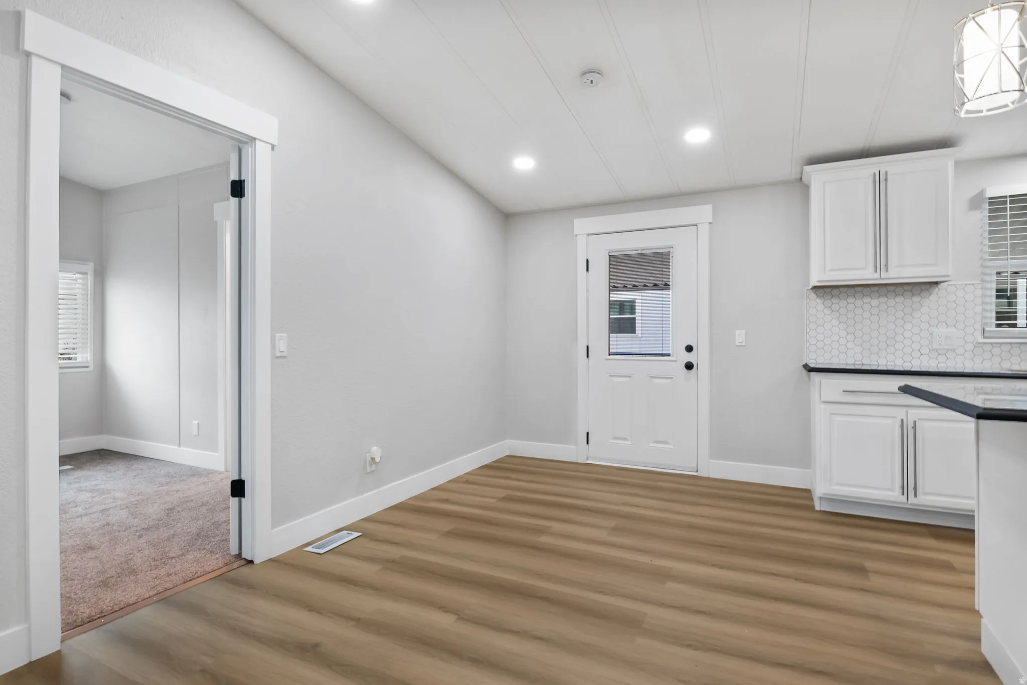 Unfurnished dining area featuring light wood-style flooring and recessed lighting