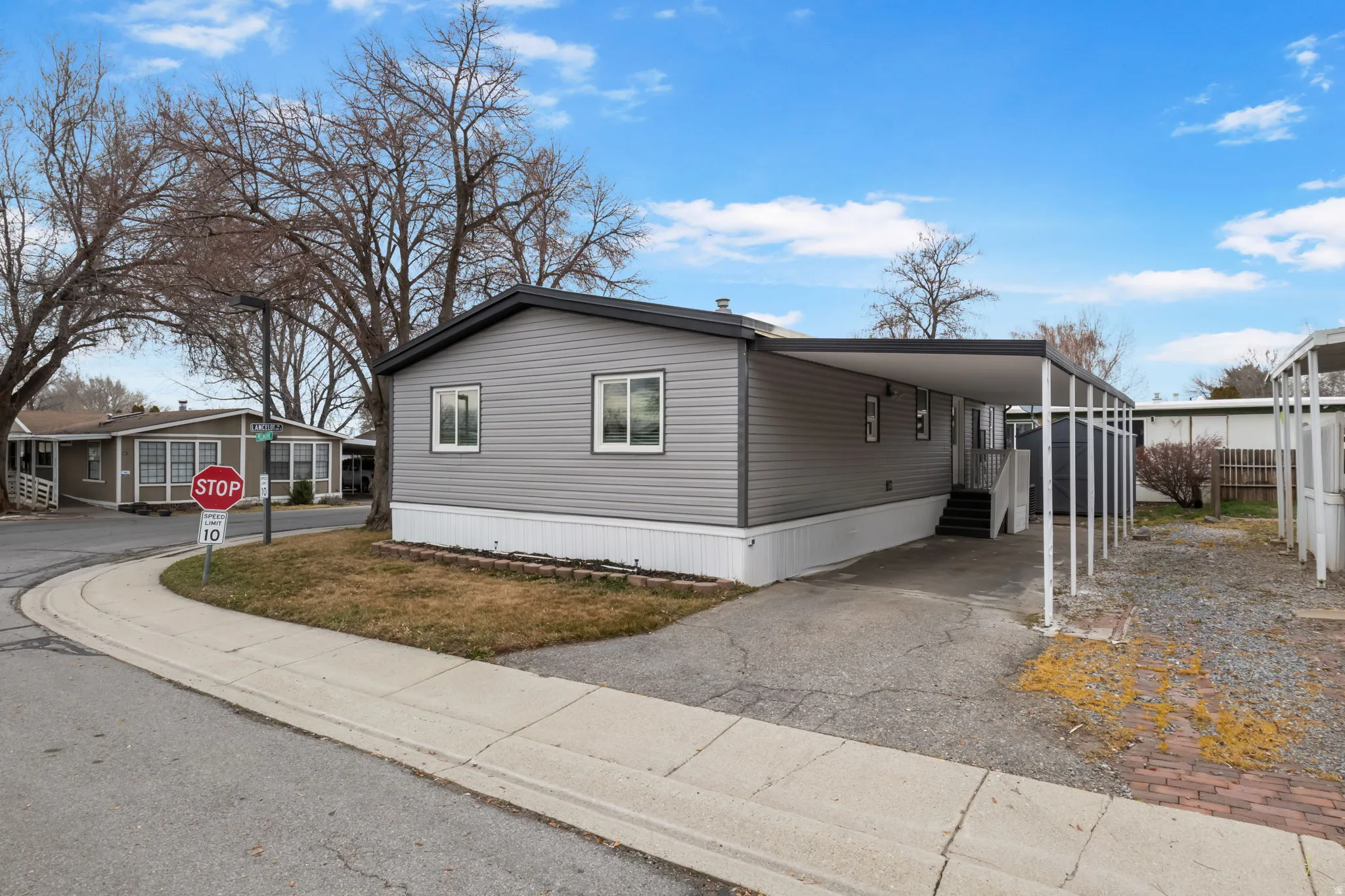 View of property exterior featuring an attached carport and driveway