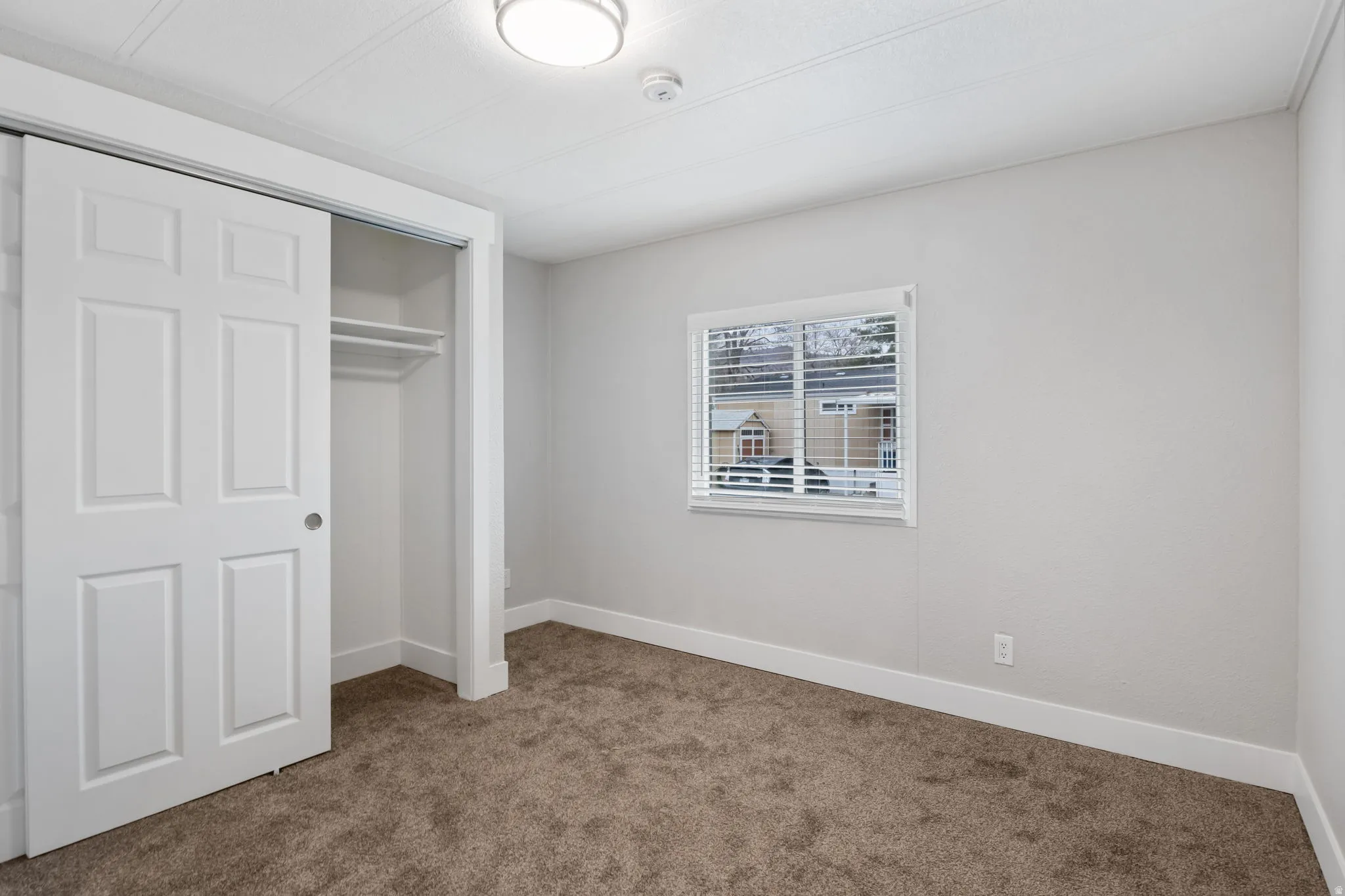 Unfurnished bedroom featuring carpet flooring and a closet