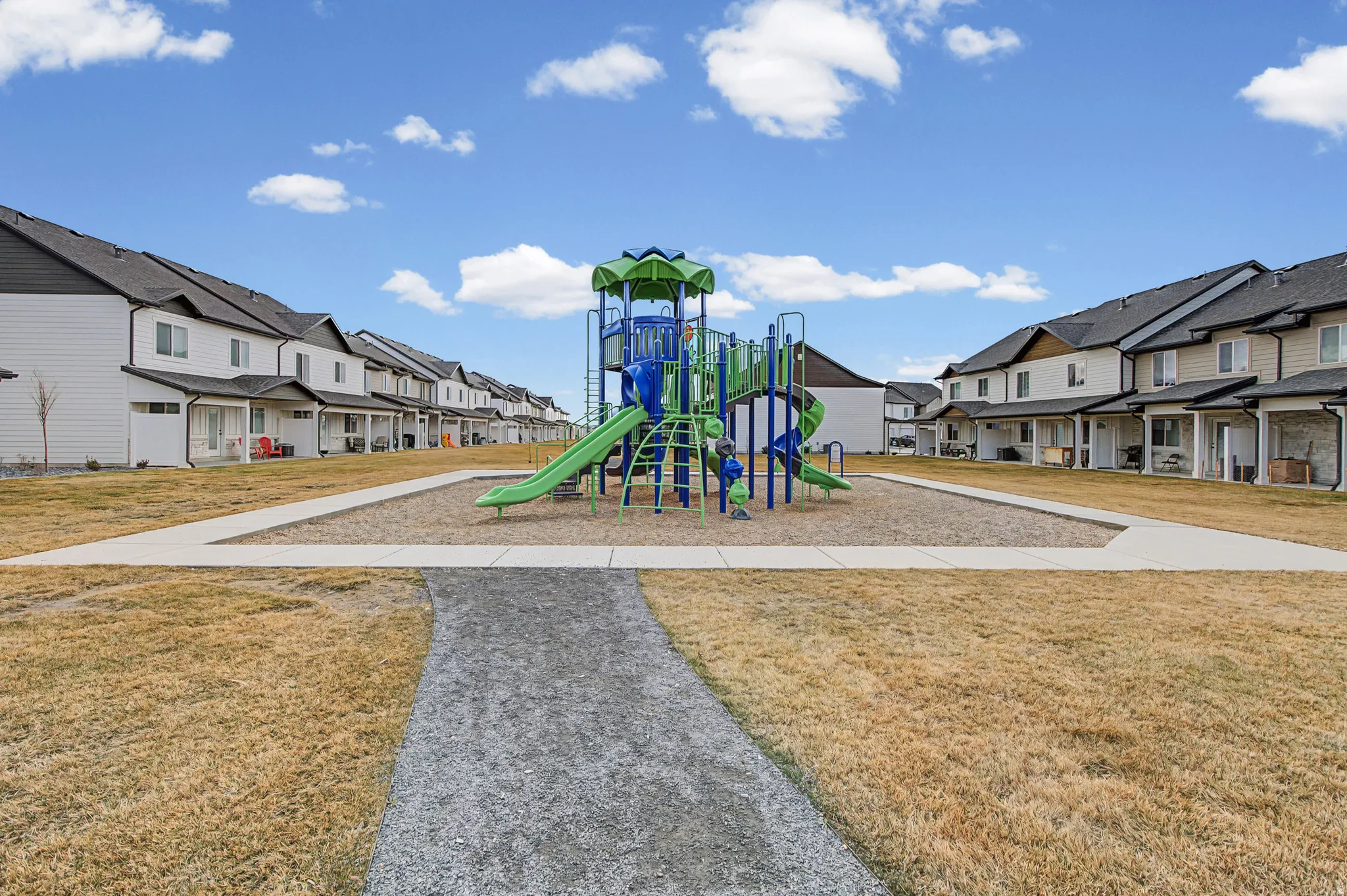 Communal playground featuring a residential view and a lawn