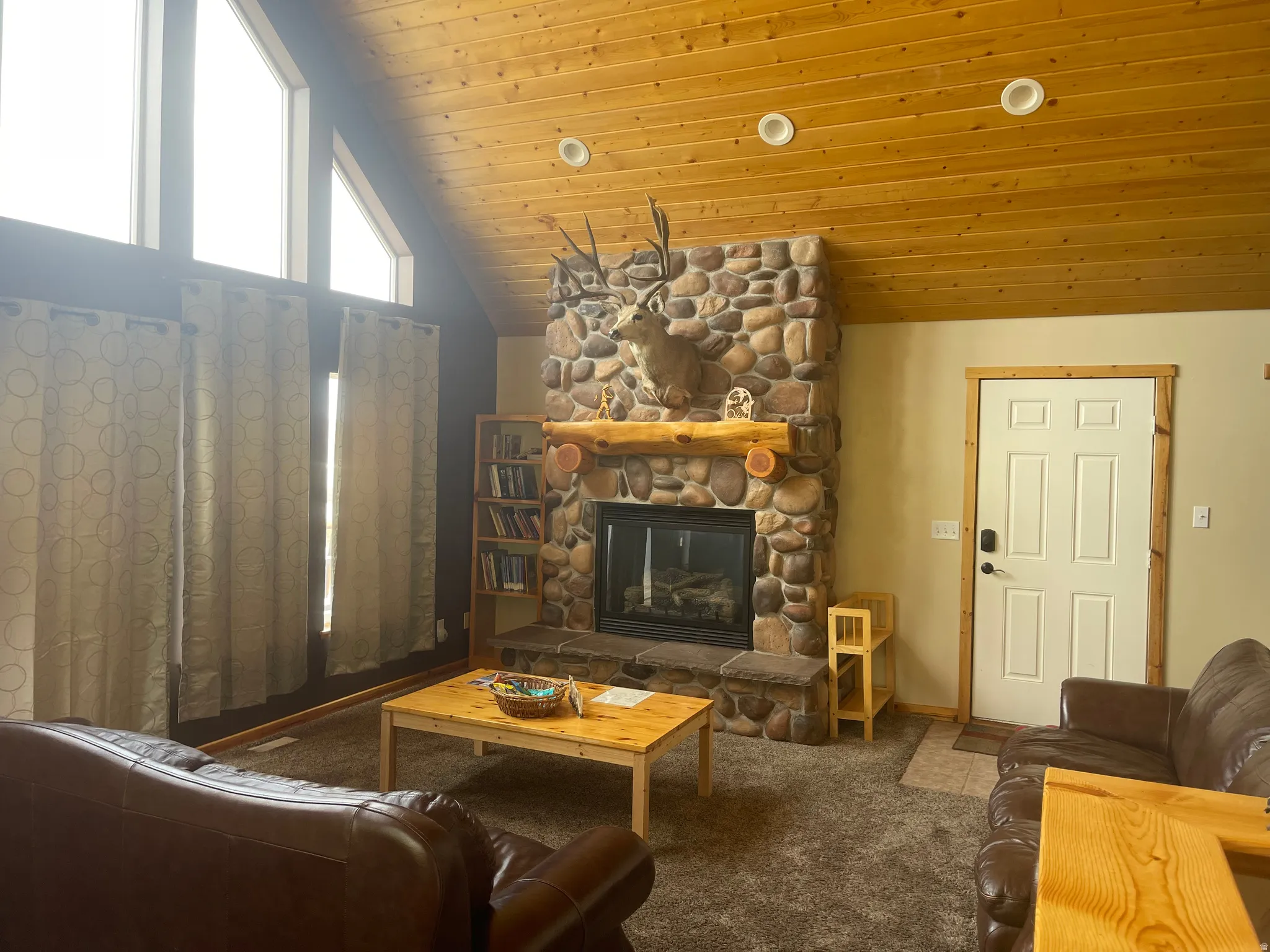 Carpeted living room with a fireplace, a vaulted wood ceiling, and recessed lighting