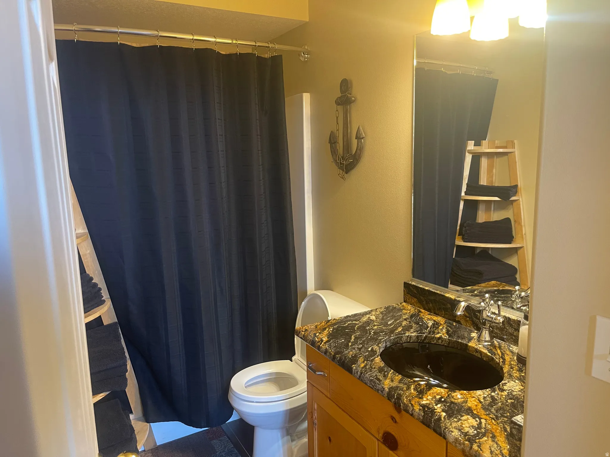 Bathroom with a shower with curtain and vanity