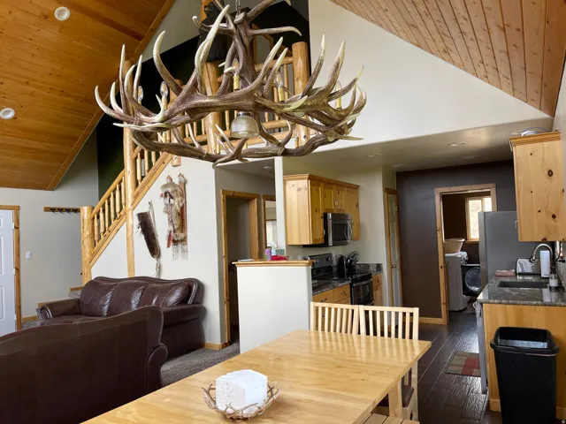 Dining area with a vaulted wooden ceiling, a chandelier, dark wood-type flooring, and washer / dryer