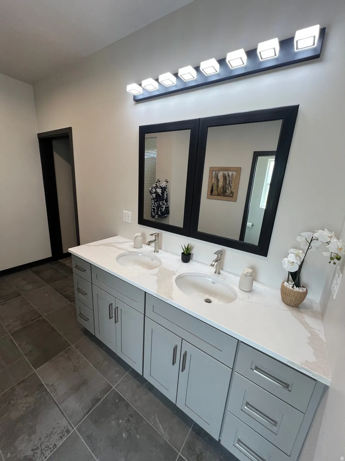 Dual vanity with a white countertop and undermount sinks, light gray cabinetry, and brushed nickel hardware