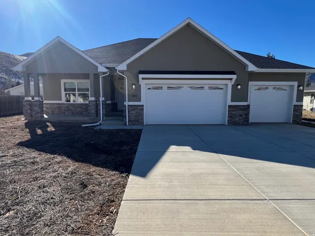 View of front of home featuring stone siding, driveway, a garage, a shingled roof, and stucco siding