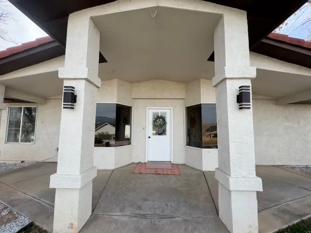 Entrance to property featuring stucco siding and a porch