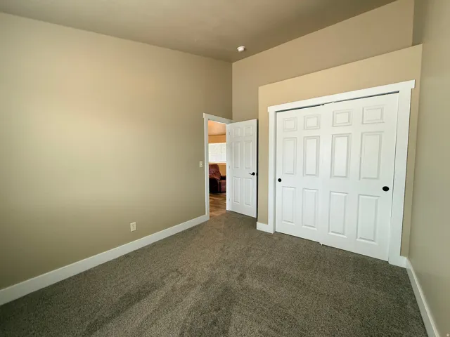 Unfurnished bedroom with dark colored carpet and a closet