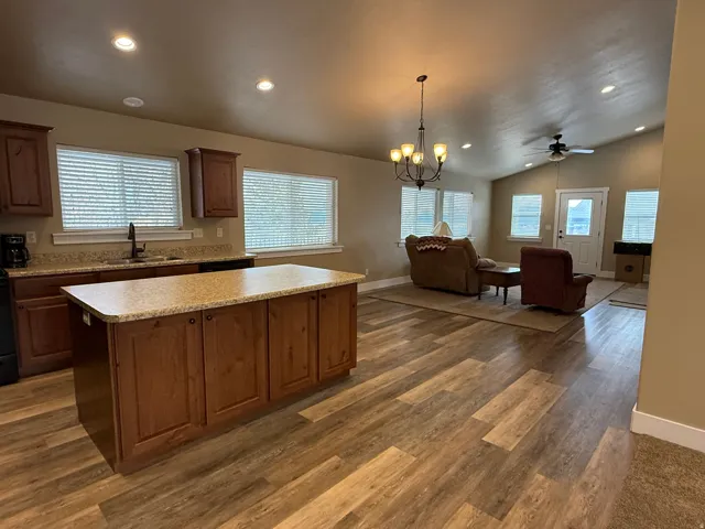 Kitchen featuring hanging lights, light countertops, a center island, open floor plan, and lofted ceiling
