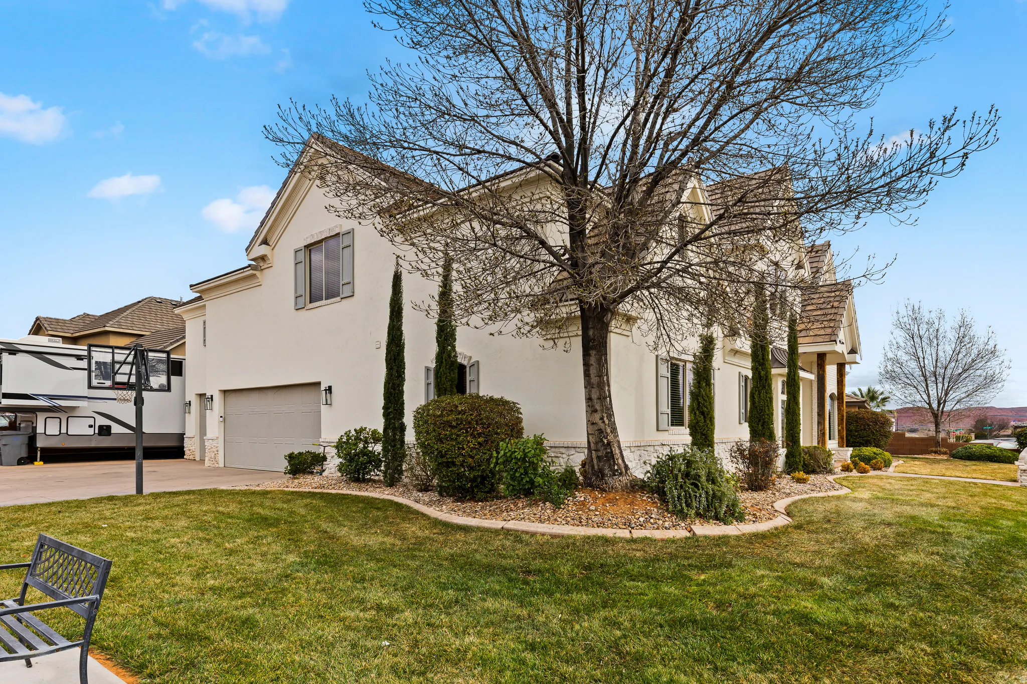 View of home's exterior with stucco siding, a garage, a lawn, and driveway
