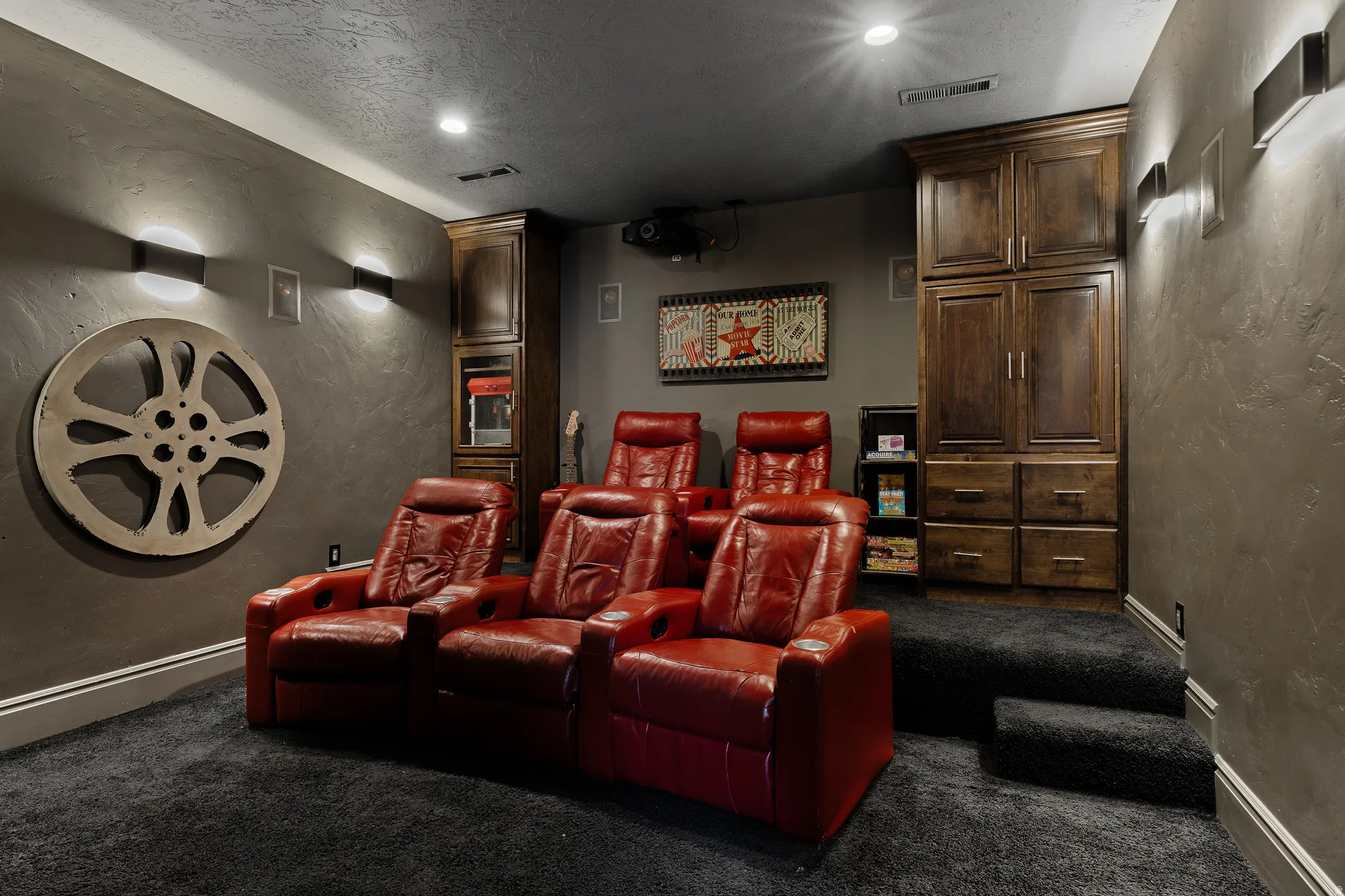 Cinema room with a textured wall, dark colored carpet, recessed lighting, and a textured ceiling