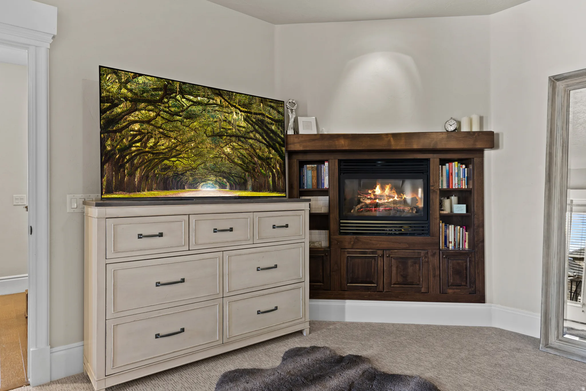 Living area featuring a glass covered fireplace and light carpet