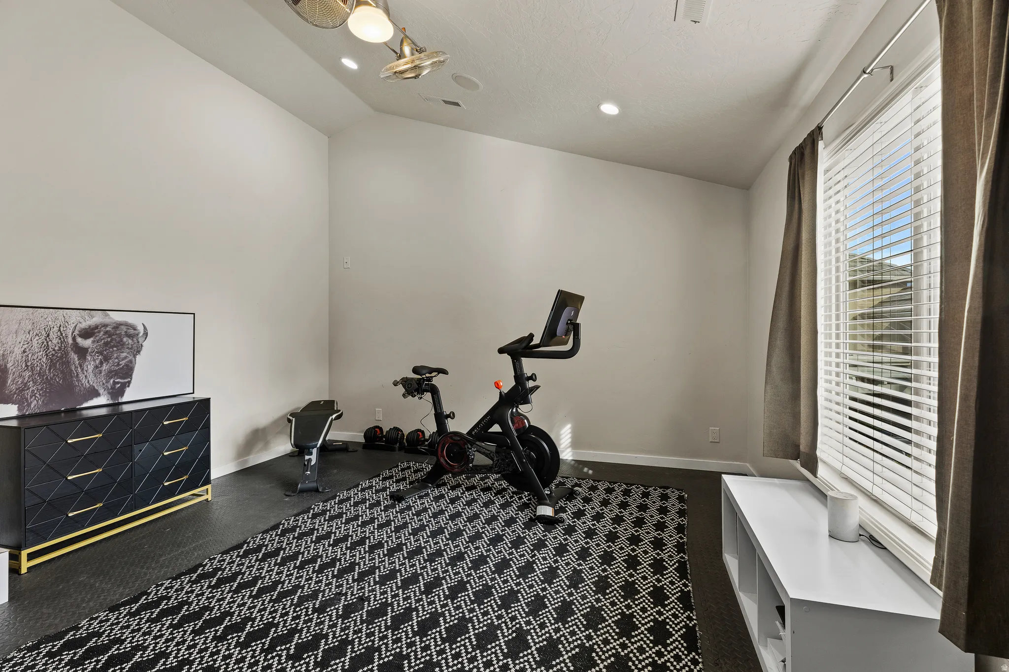 Exercise room with vaulted ceiling and recessed lighting