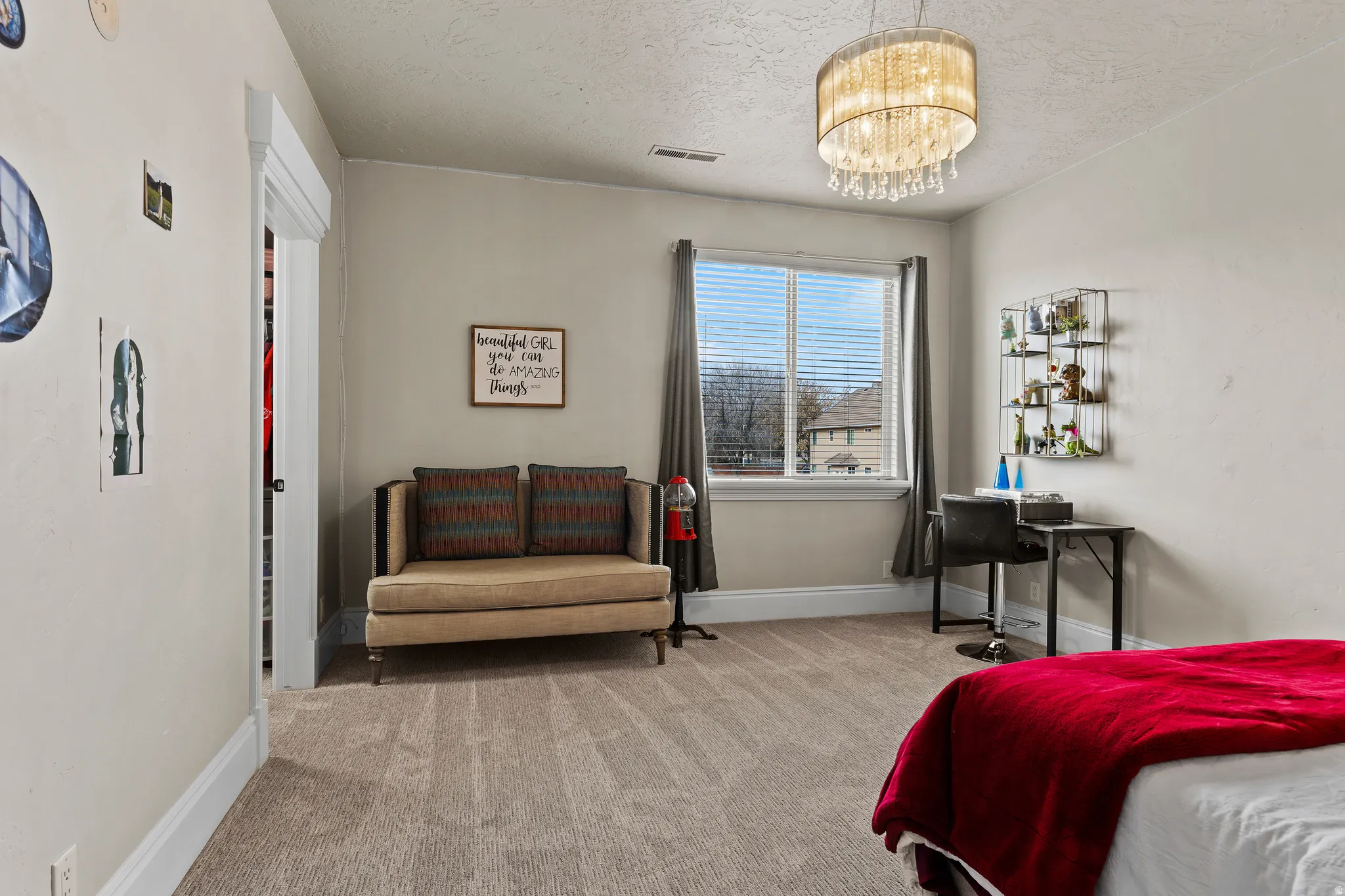 Bedroom with hanging lights, carpet, and a textured ceiling