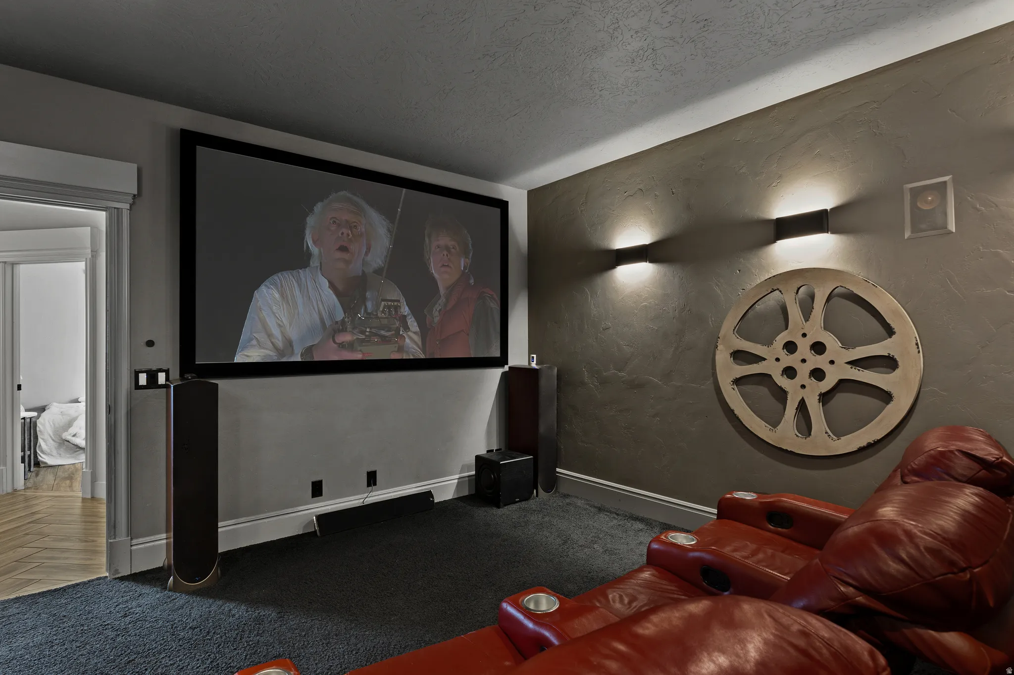 Carpeted cinema with baseboards and a textured ceiling