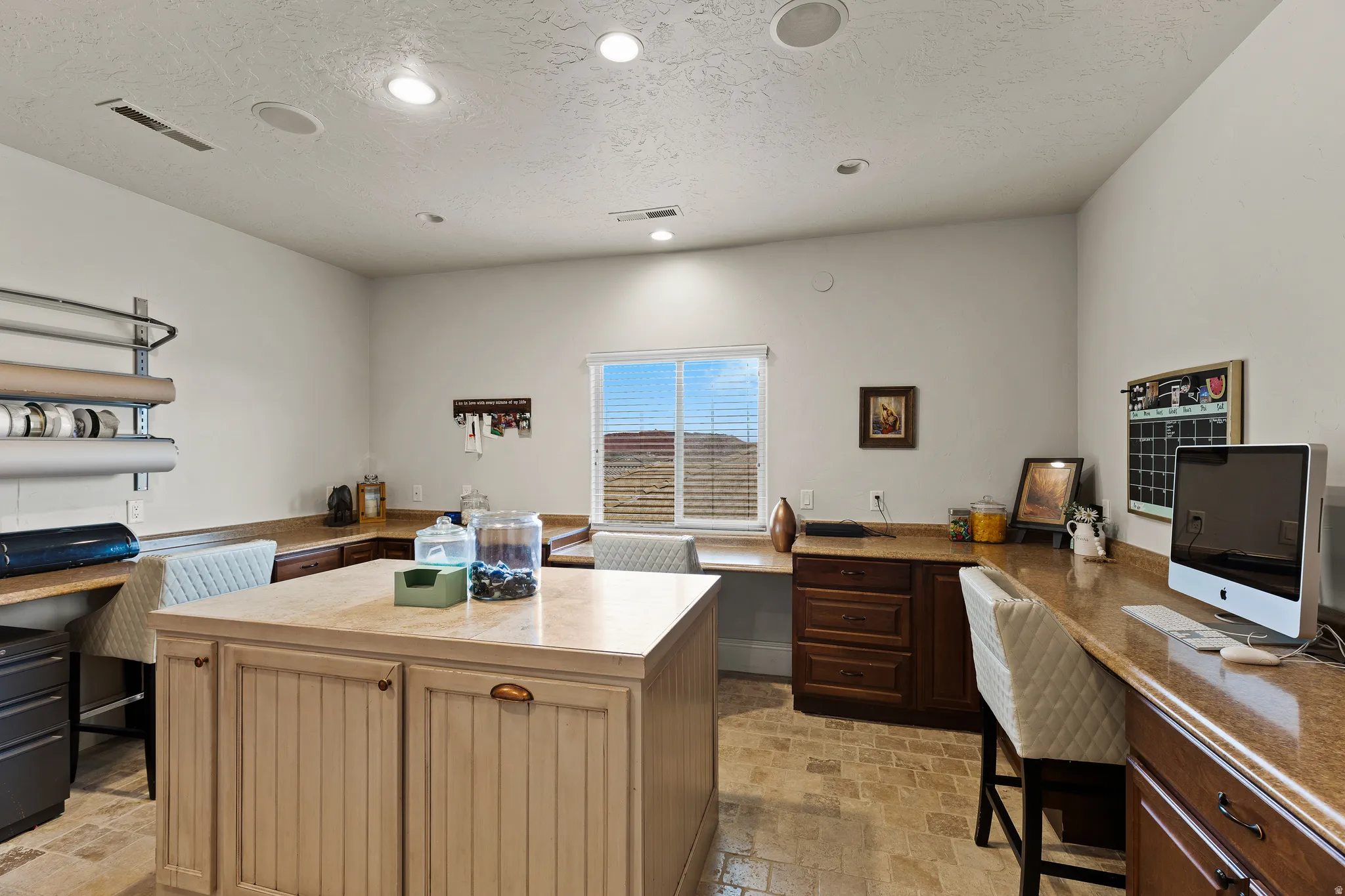 Office with built in desk, light stone finish floors, a textured ceiling, and recessed lighting