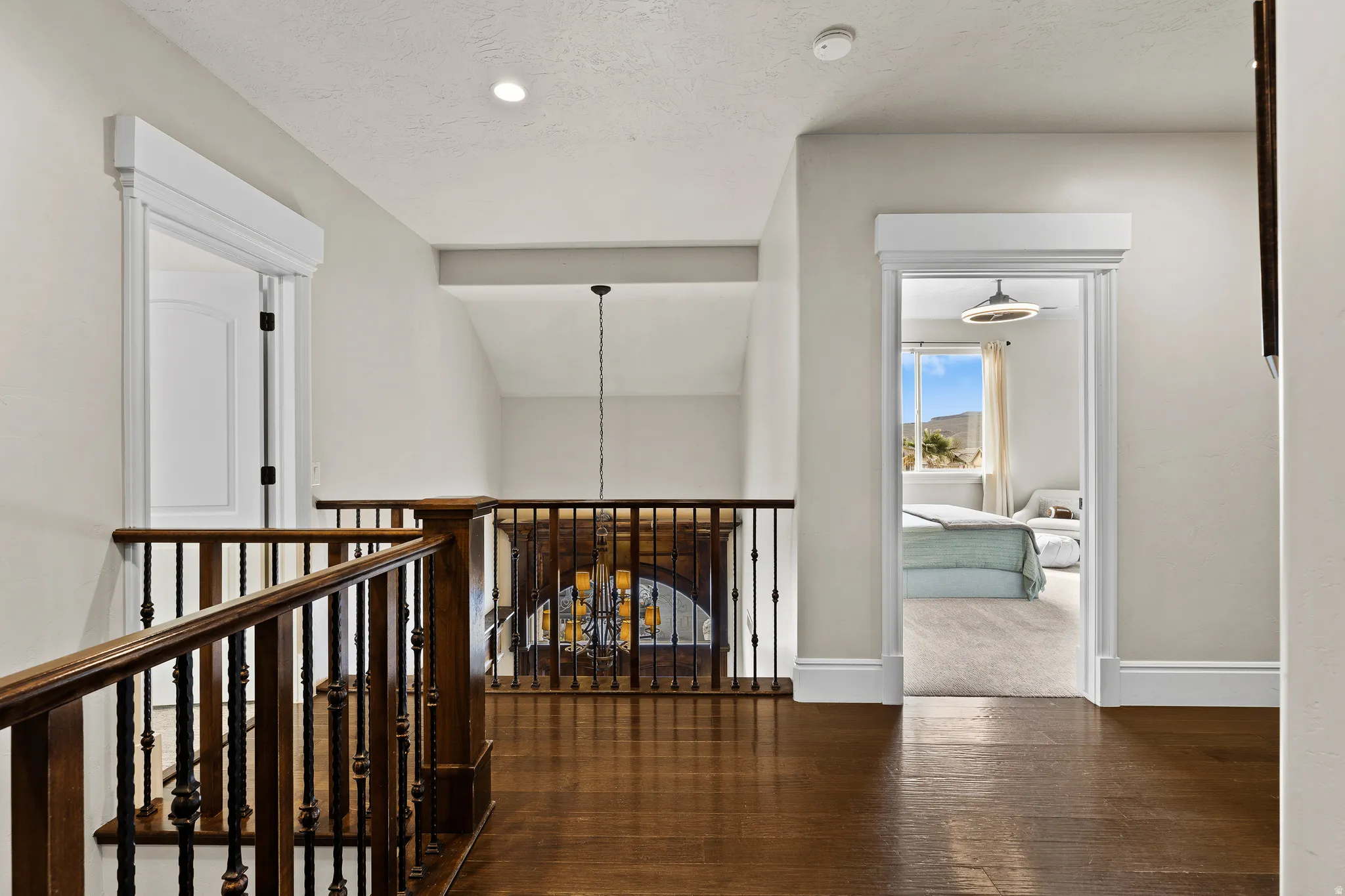 Hallway featuring dark wood-style floors, suspended lighting, and a textured ceiling
