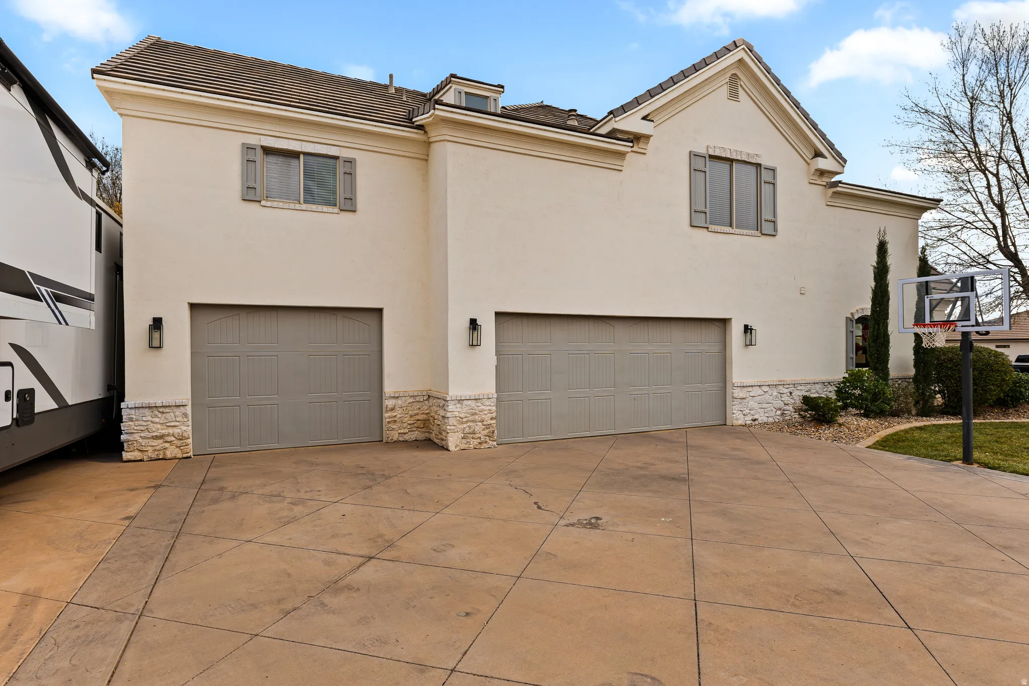 View of front of home with a garage, a tiled roof, and stone siding
