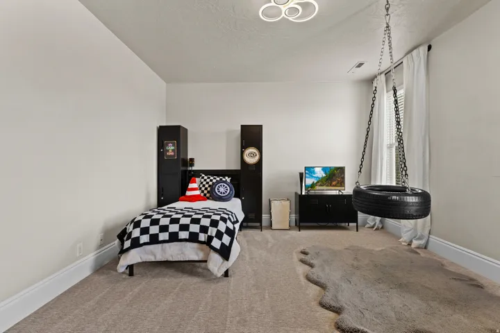 Carpeted bedroom featuring baseboards and a textured ceiling
