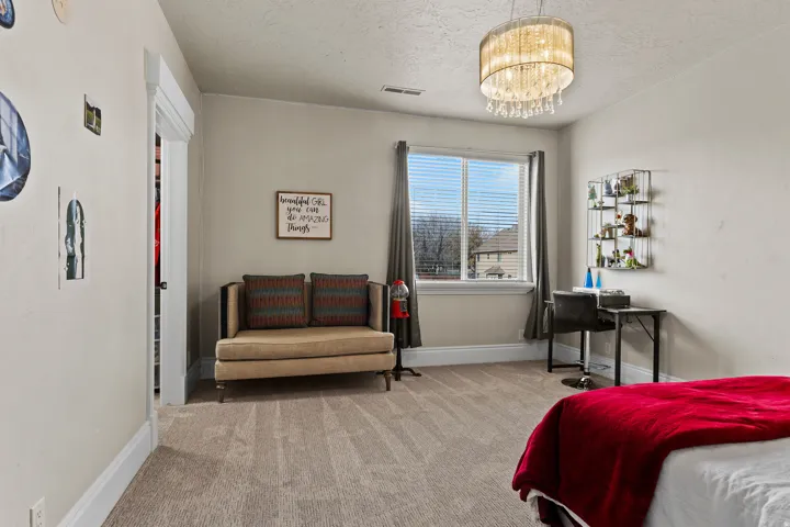 Bedroom with hanging lights, carpet, and a textured ceiling