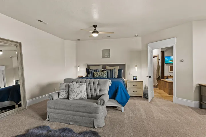 Carpeted bedroom featuring baseboards and a ceiling fan