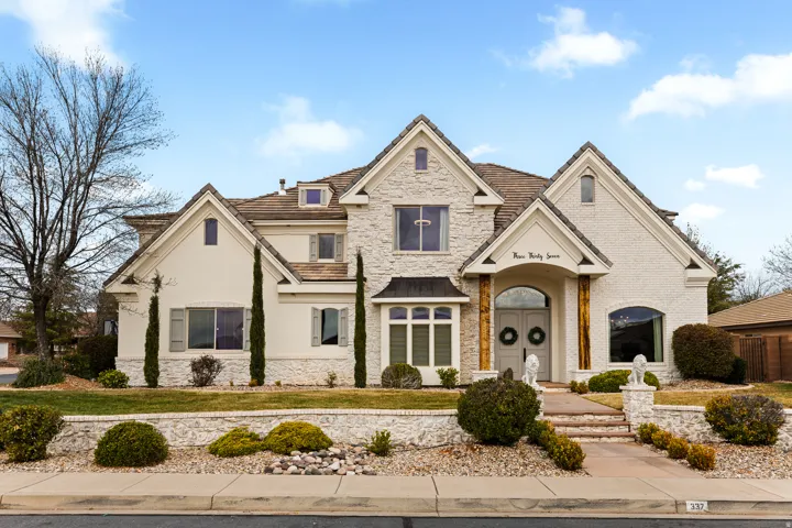 French country home with stone siding and stucco siding