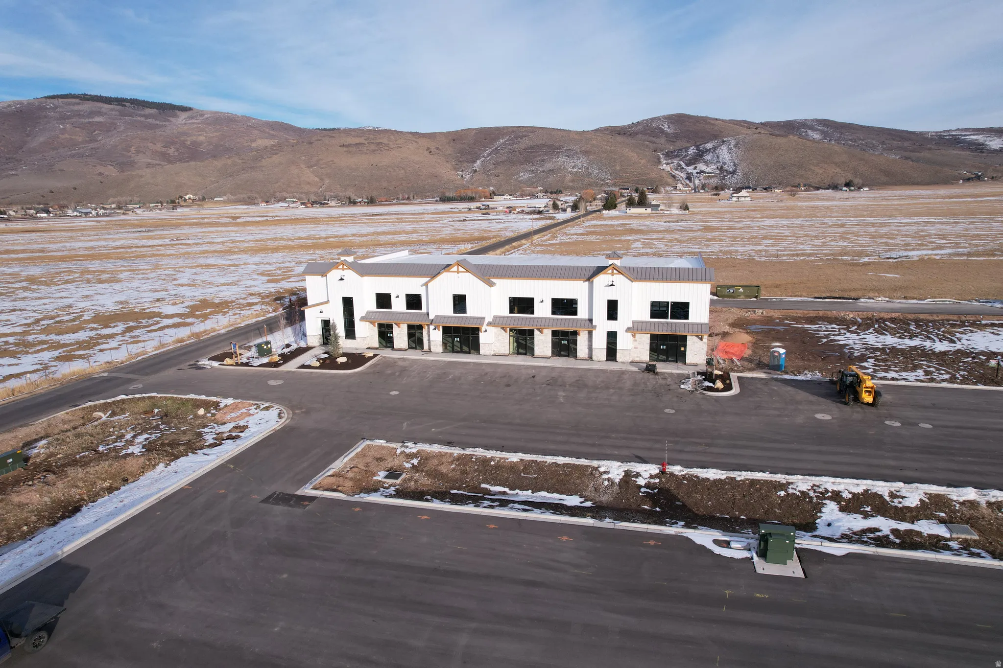 Snowy aerial view featuring a mountain view and a rural view