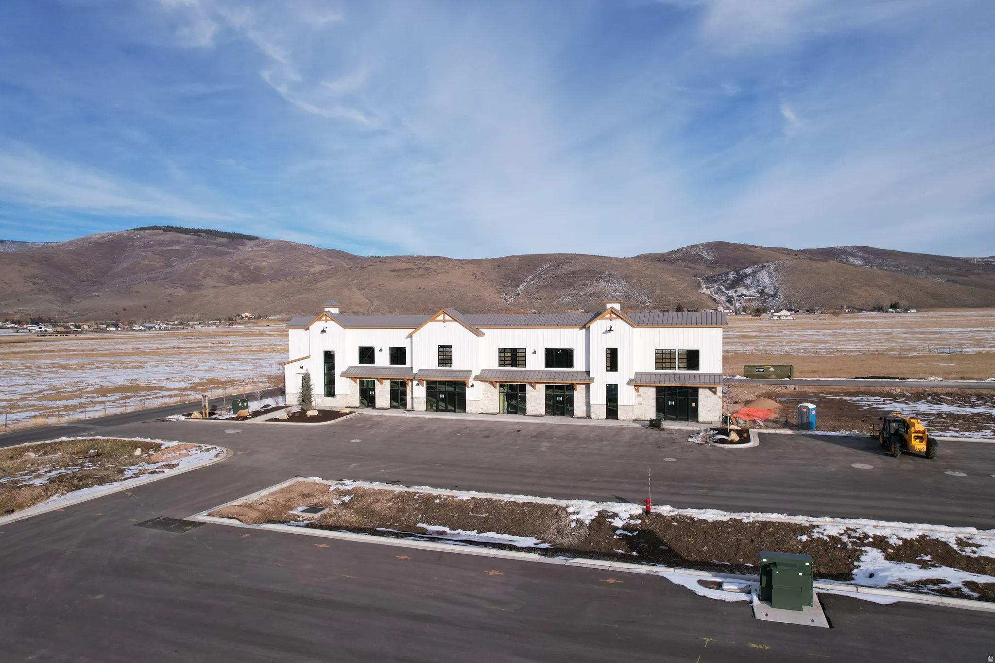 Aerial view of property and surrounding area featuring a mountainous background