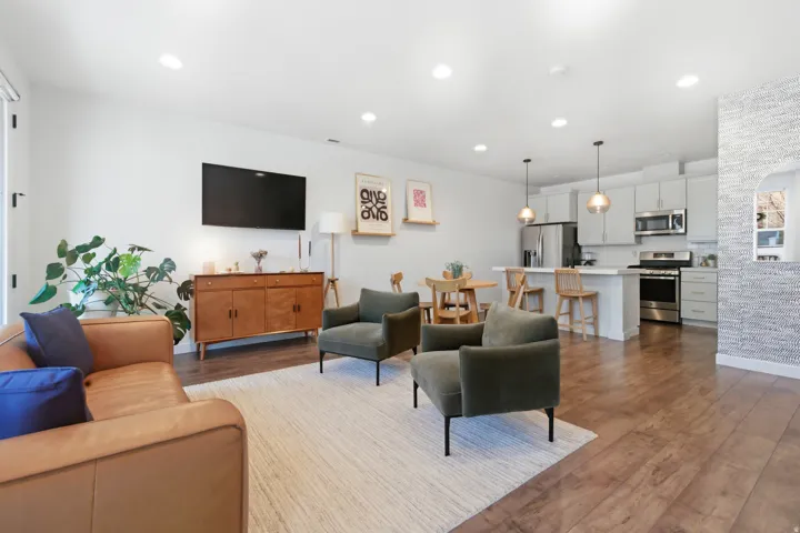 Living area with dark wood-type flooring and recessed lighting