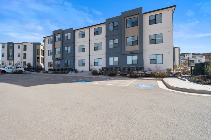 View of apartment building / complex with uncovered parking