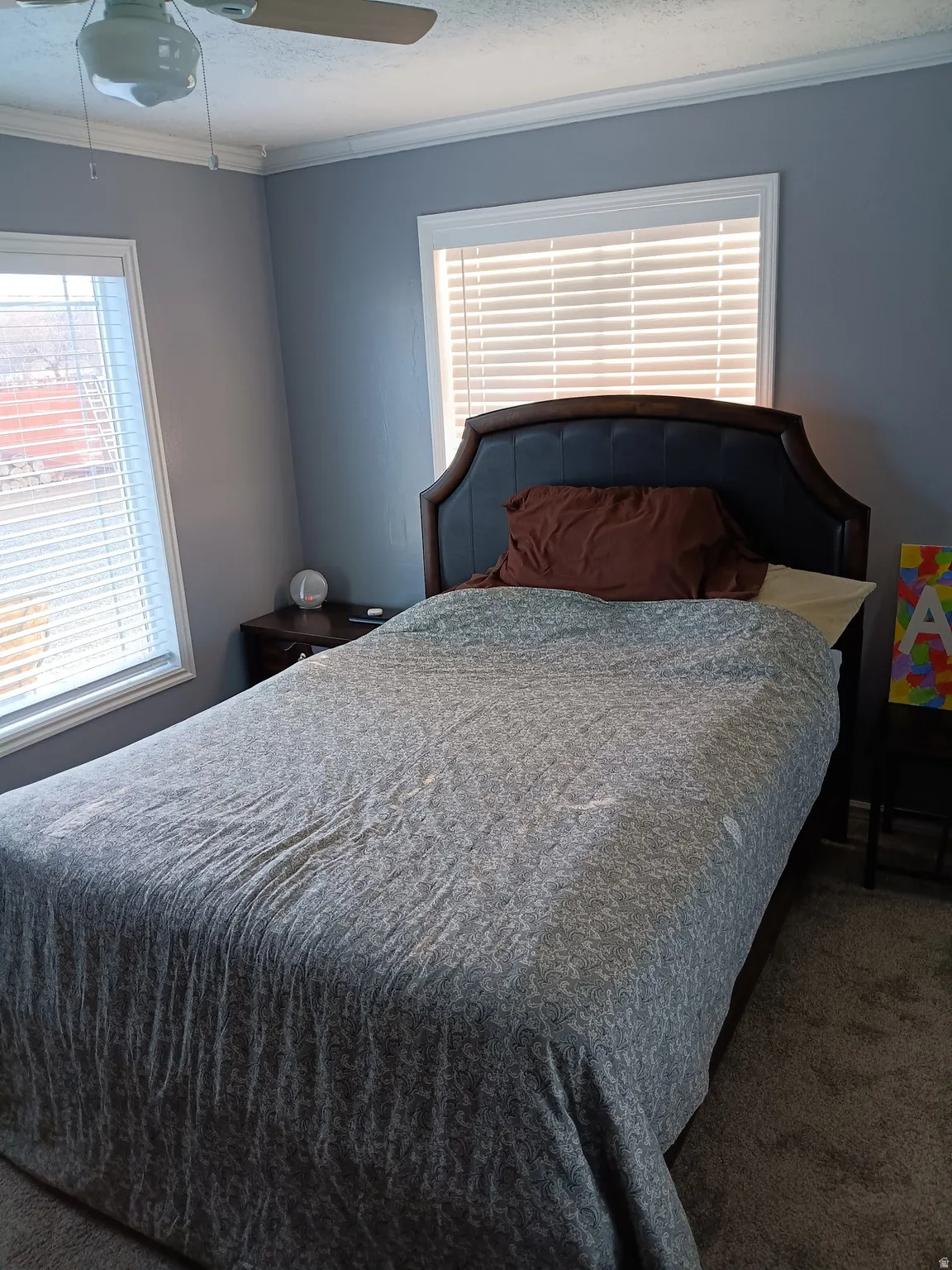 Bedroom 2 featuring carpet floors, multiple windows, a ceiling fan, and ornamental molding