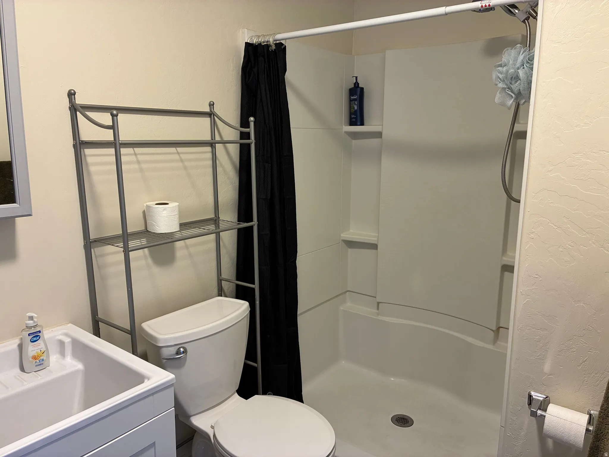 Full bathroom with a stall shower and a textured wall