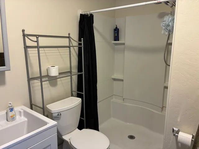 Full bathroom with a stall shower and a textured wall