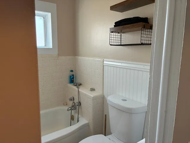 Bathroom with a bath and hand held shower attachment