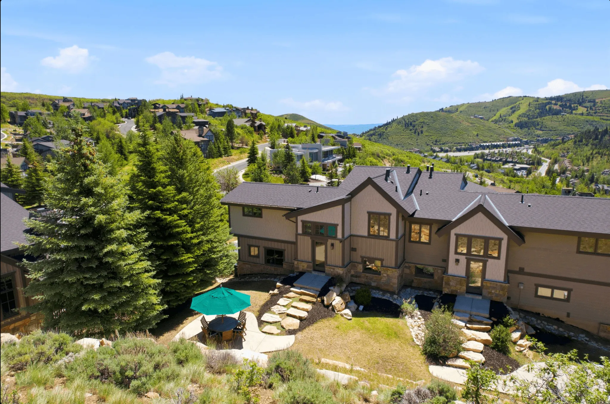 Multi-level residence featuring a dark shingle roof and a combination of stone and siding exterior
