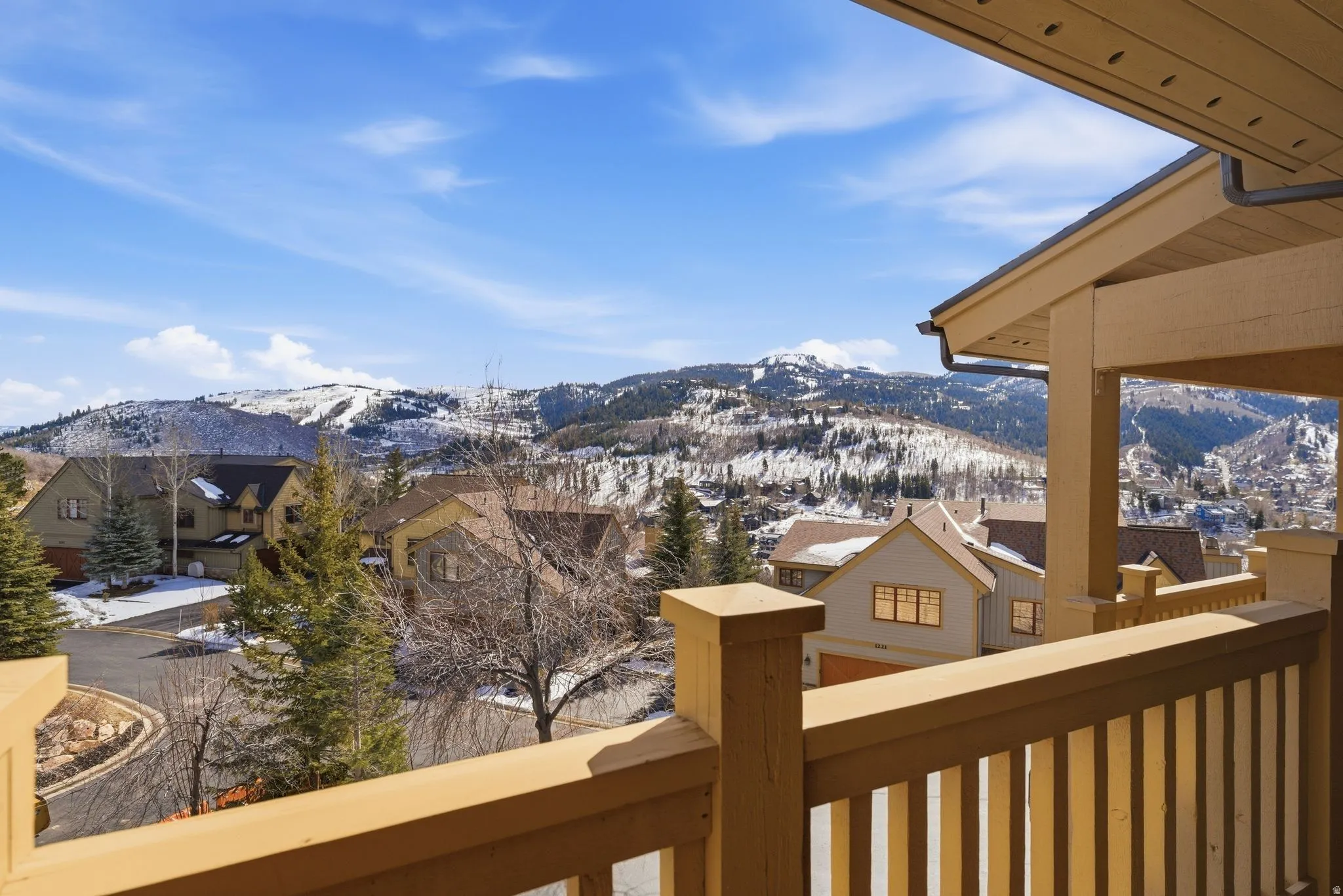 Private balcony featuring a wood railing and a covered patio area