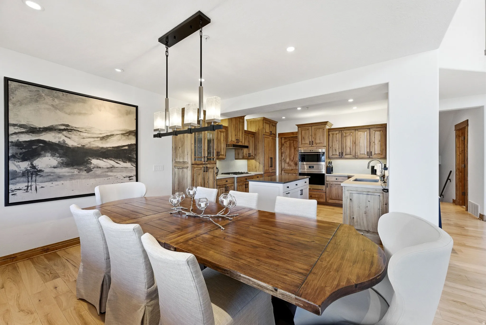 Dining area featuring wood-finish flooring, a rectangular chandelier with frosted glass shades, and recessed lighting