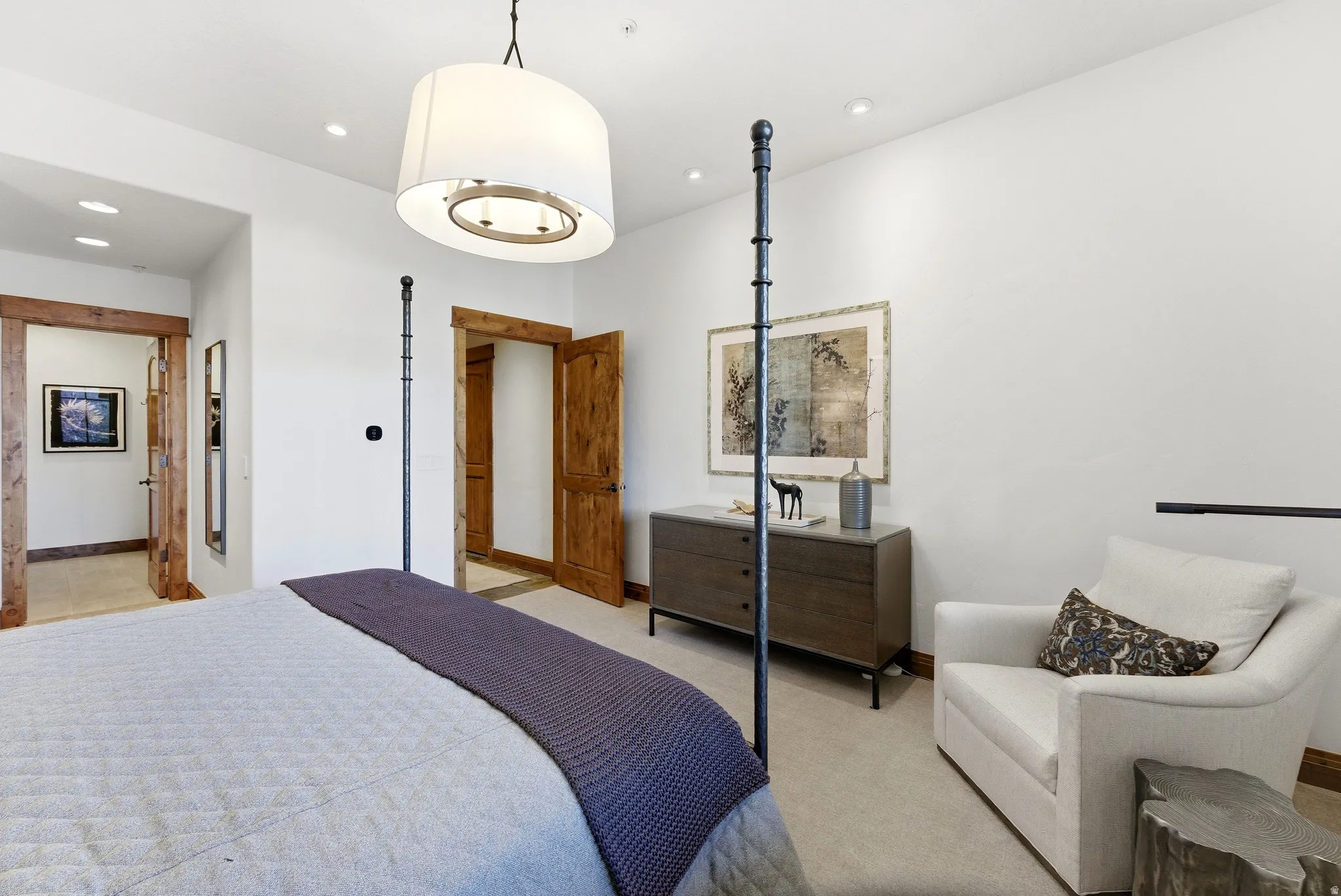 Spacious room featuring wood-finish door frames, recessed lighting, a ceiling-mounted drum pendant, and light-toned carpeting
