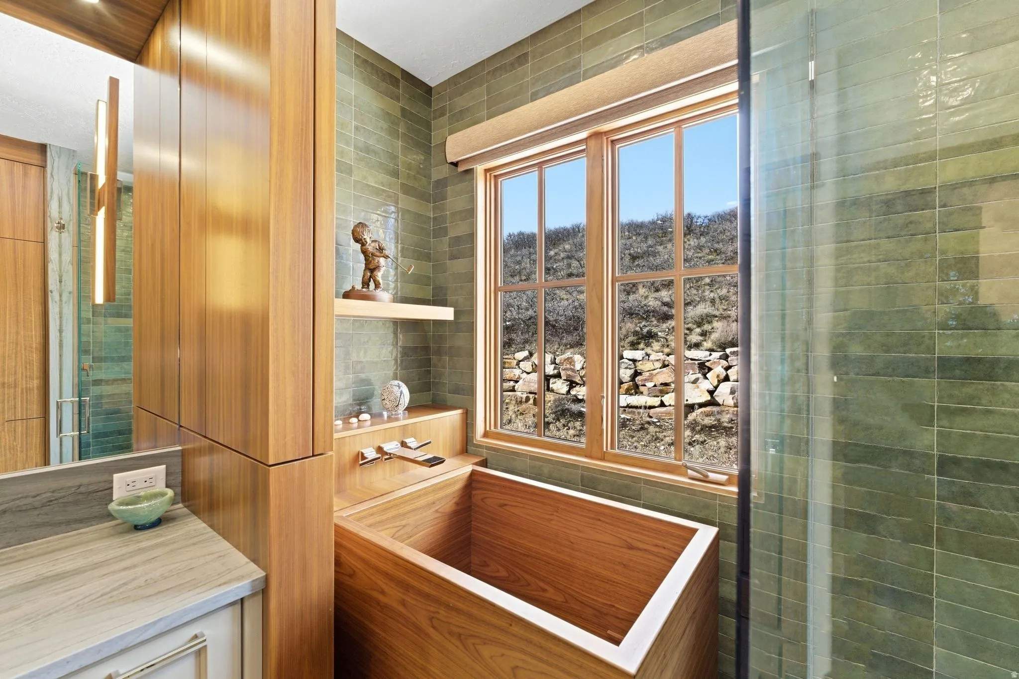 Bathroom featuring a wood-finish soaking tub, large wood-framed window, and green subway tile walls