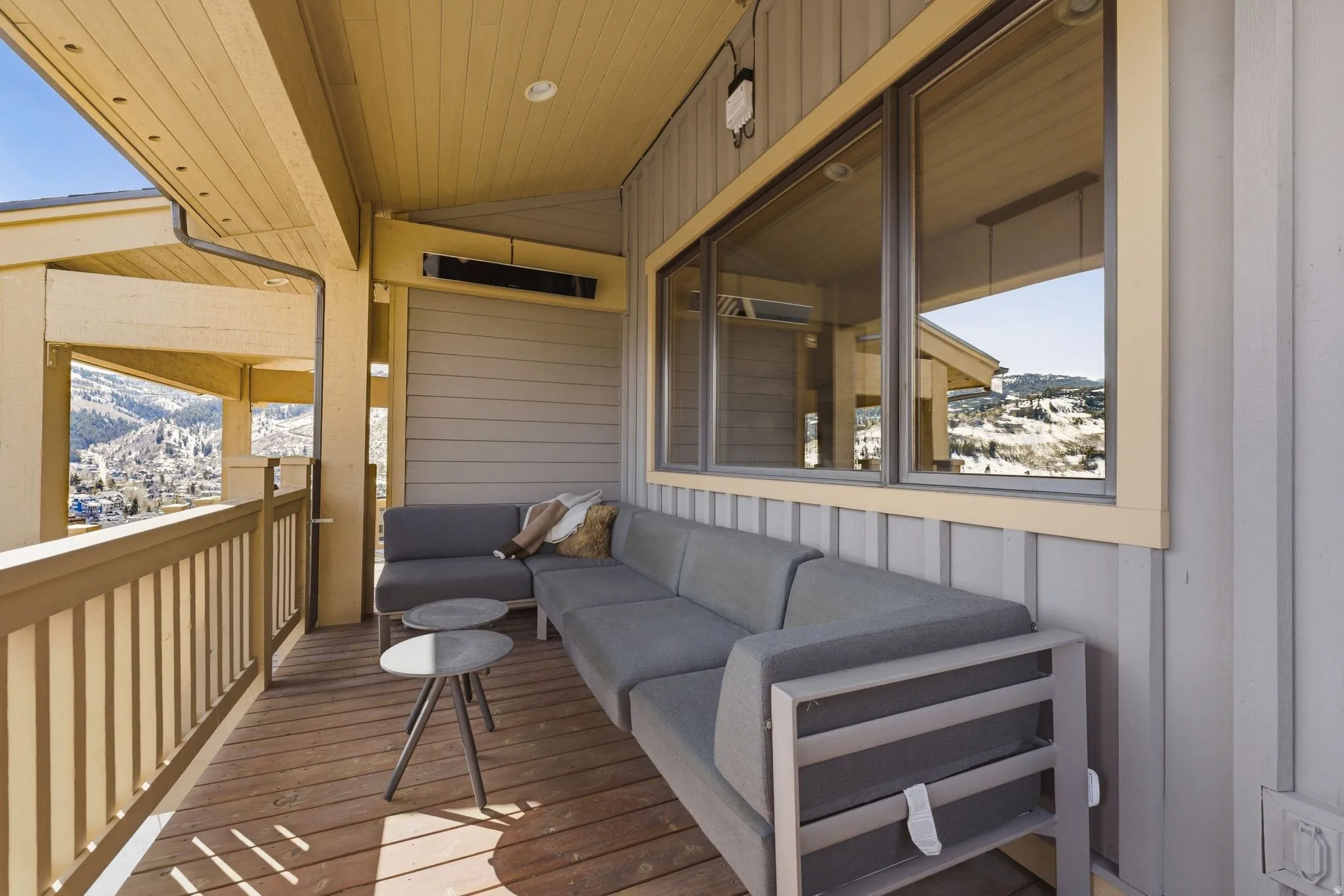 Covered outdoor deck with wood-finish flooring and railing