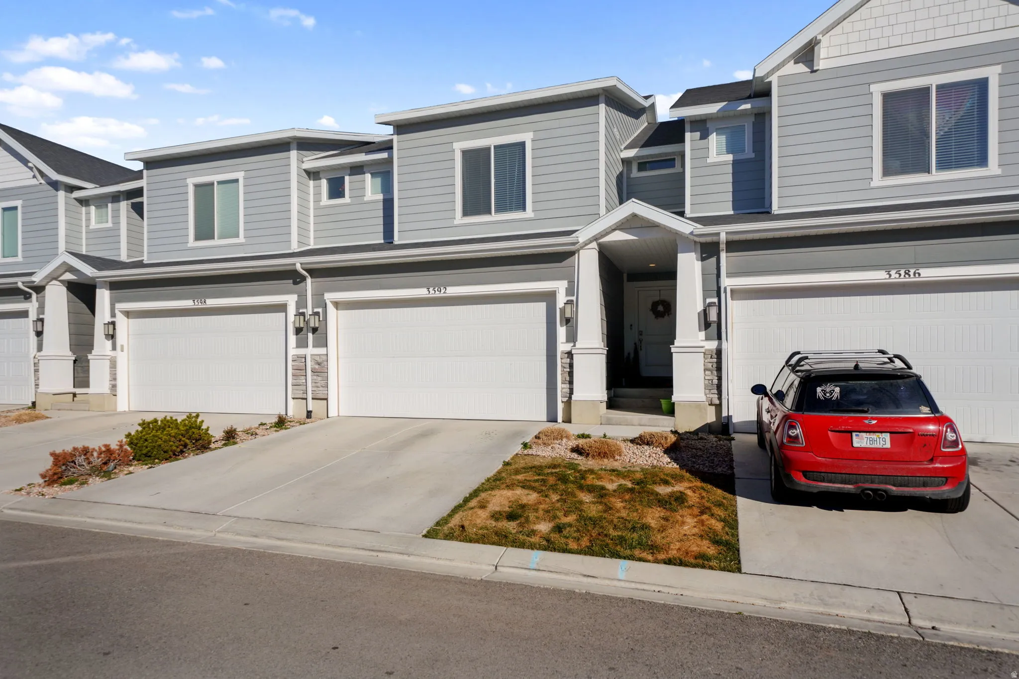 View of front of home with an attached garage, driveway, and a residential view