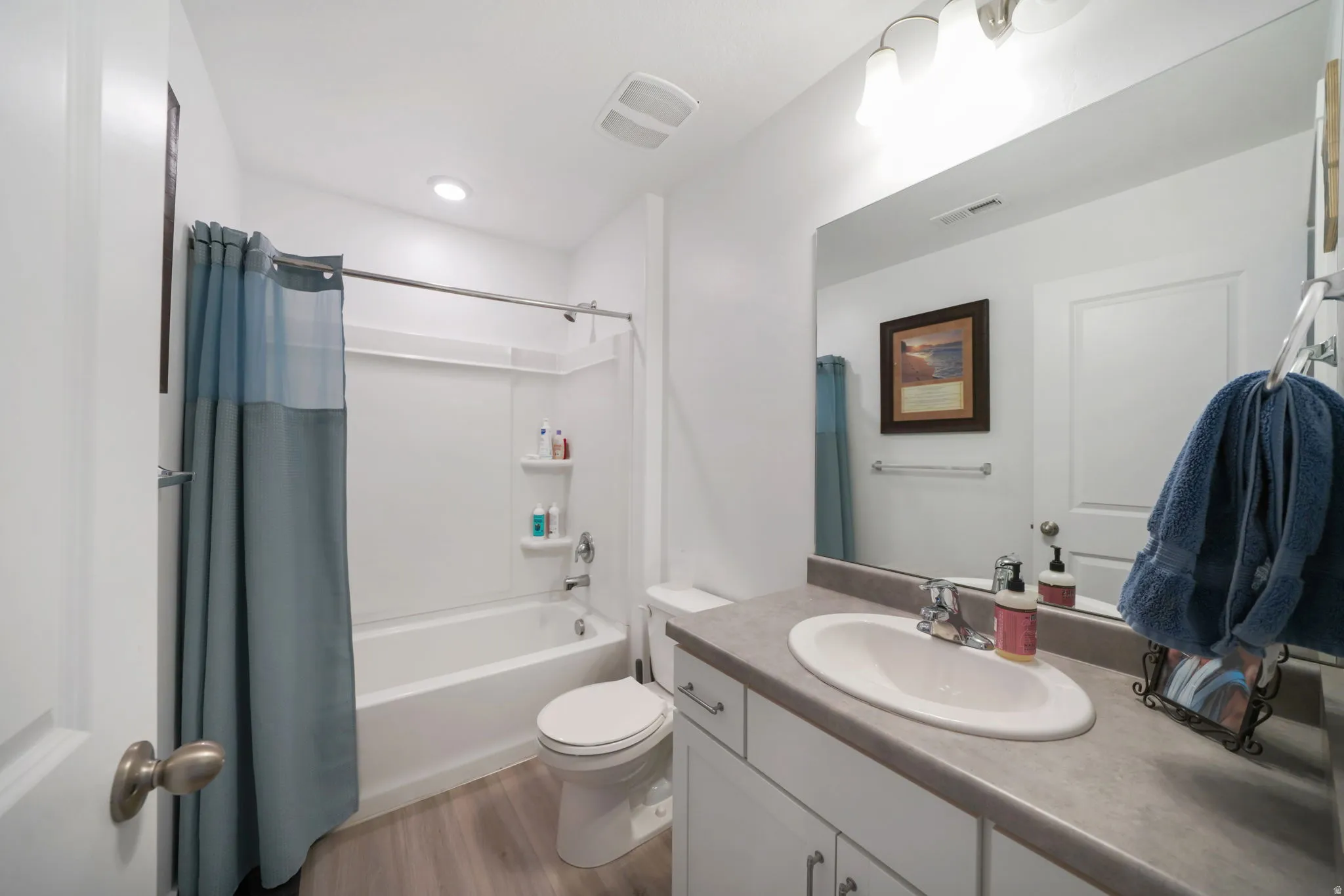 Full bathroom featuring vanity, light wood-style flooring, and shower / tub combo